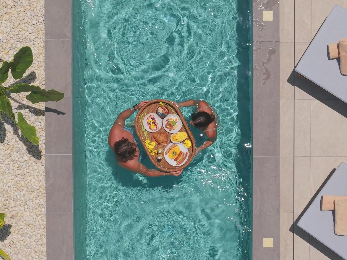 Guests enjoying a floating breakfast in their villa’s private pool