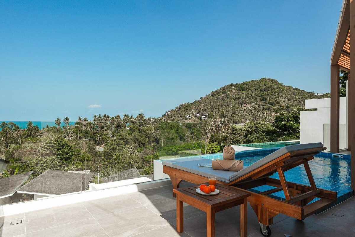 Pool terrace with a sun lounger and sea view on a sunny day in Koh Samui
