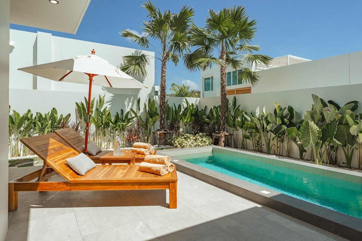 Private pool and palm trees at a Bang Tao villa in Phuket under a blue sky